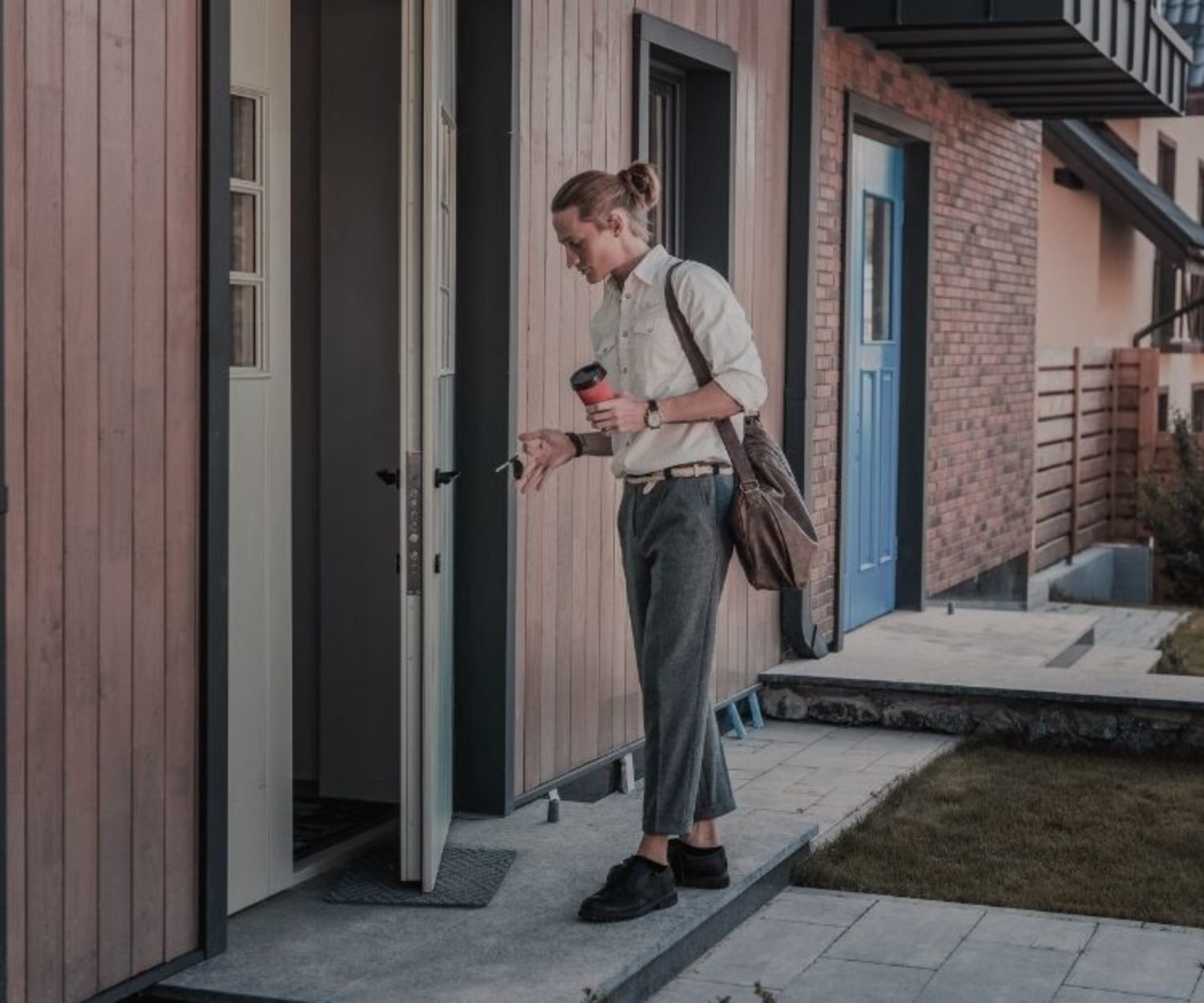 Young man unlocking his front door