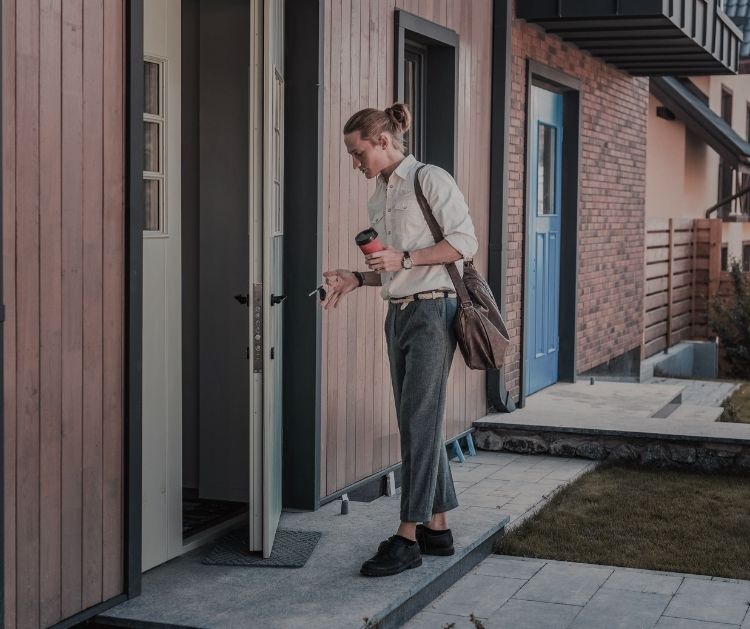 Young man unlocking his front door