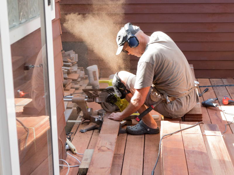 A builder sawing wood
