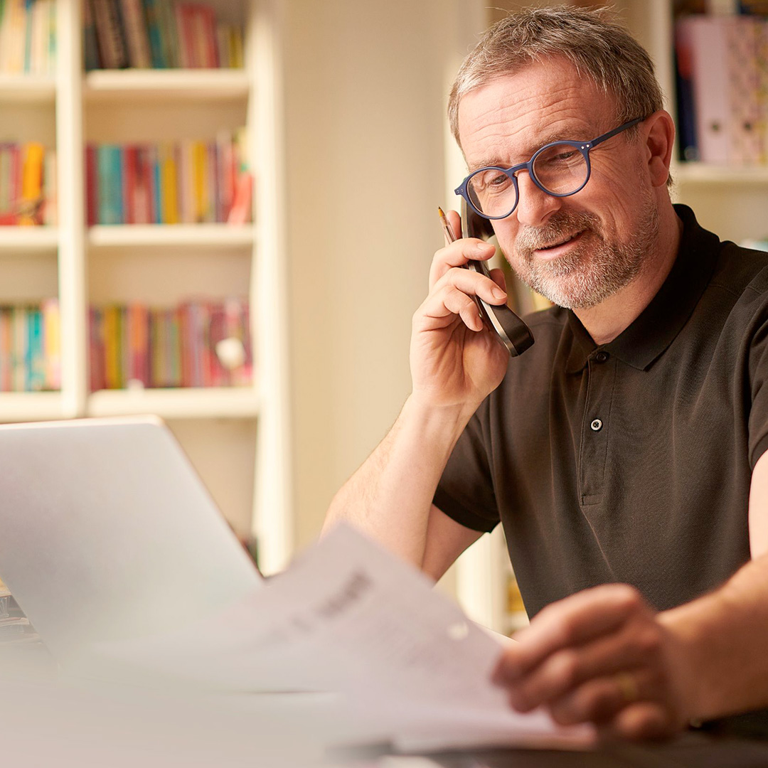 A man at a desk on a phone