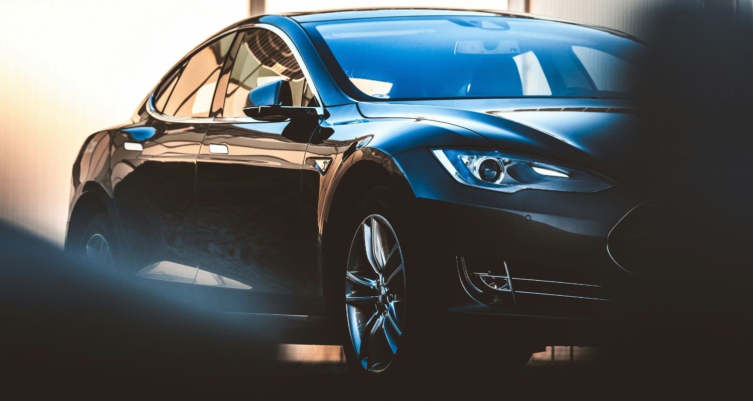 Electric vehicles smart move or costly detour header image - UFINANCIAL Black luxury sedan photographed from a low front-left angle, showing glossy curves and chrome wheel in a showroom lighting.