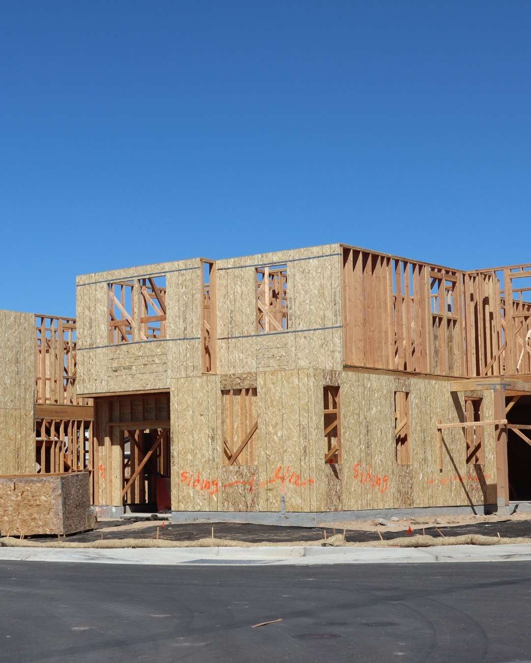 Multiple subdivided houses under construction on a street corner.