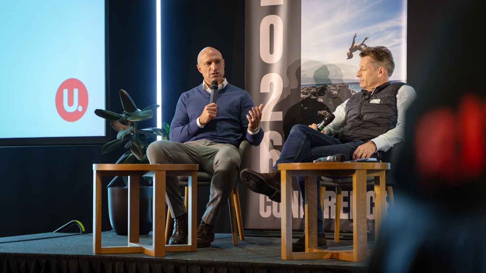 Chris Judd speaks alongside Kris Court on stage at the 2026 UFinancial conference.