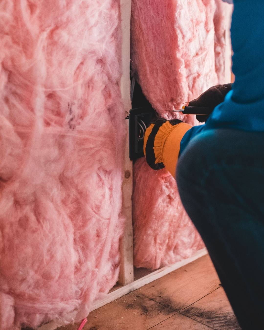 Close up installing pink insulation