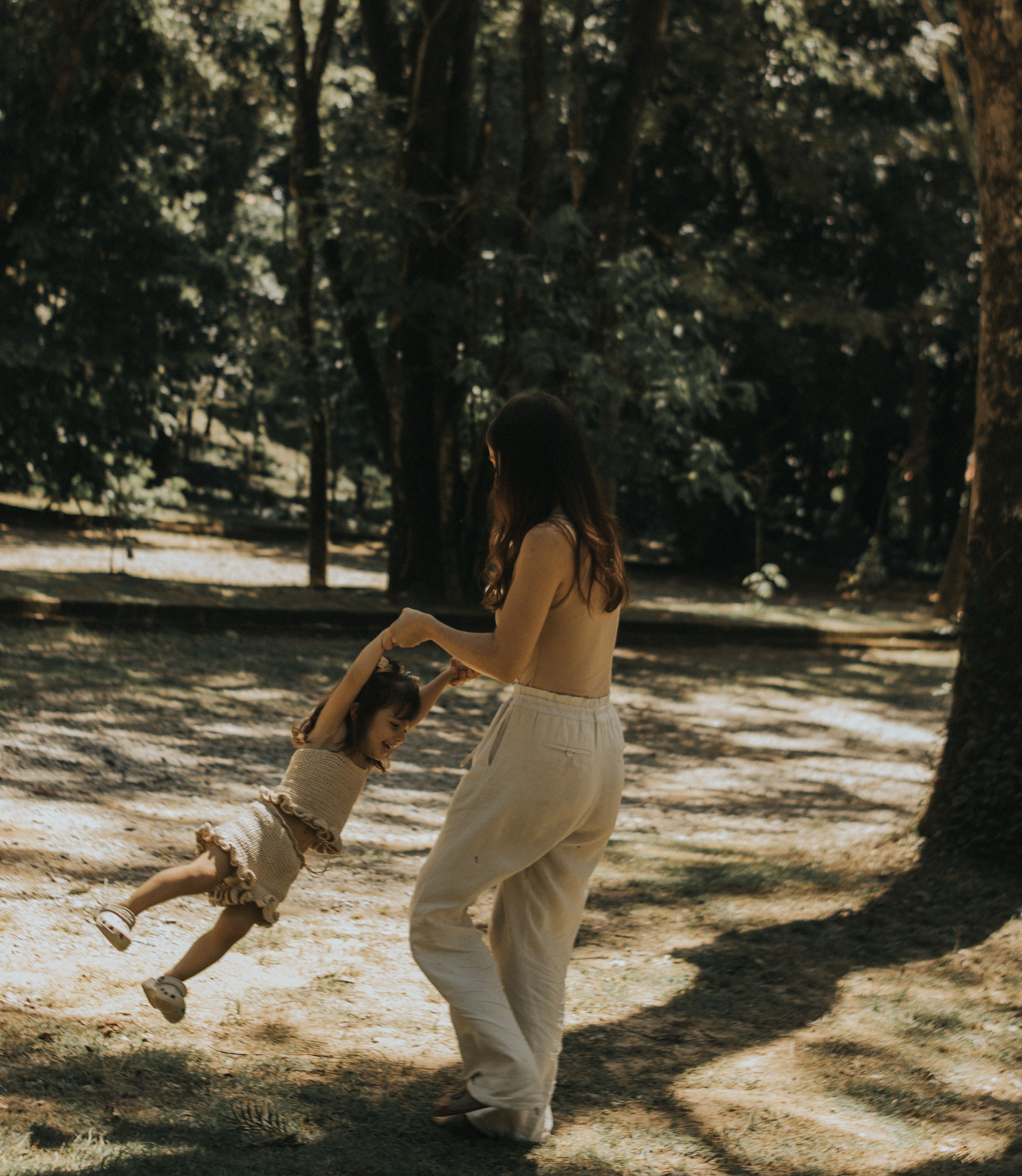 Mother and daughter, carefree and playing in a park