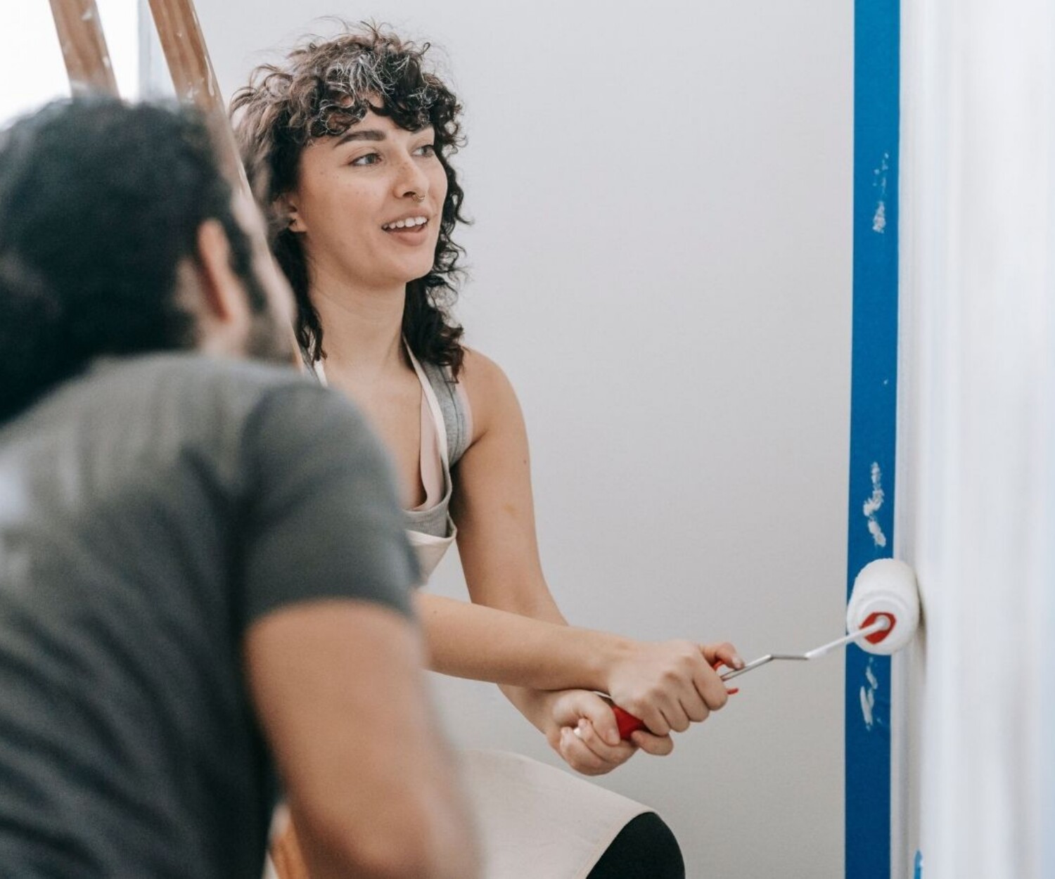 Couple painting their walls white to add value to their property