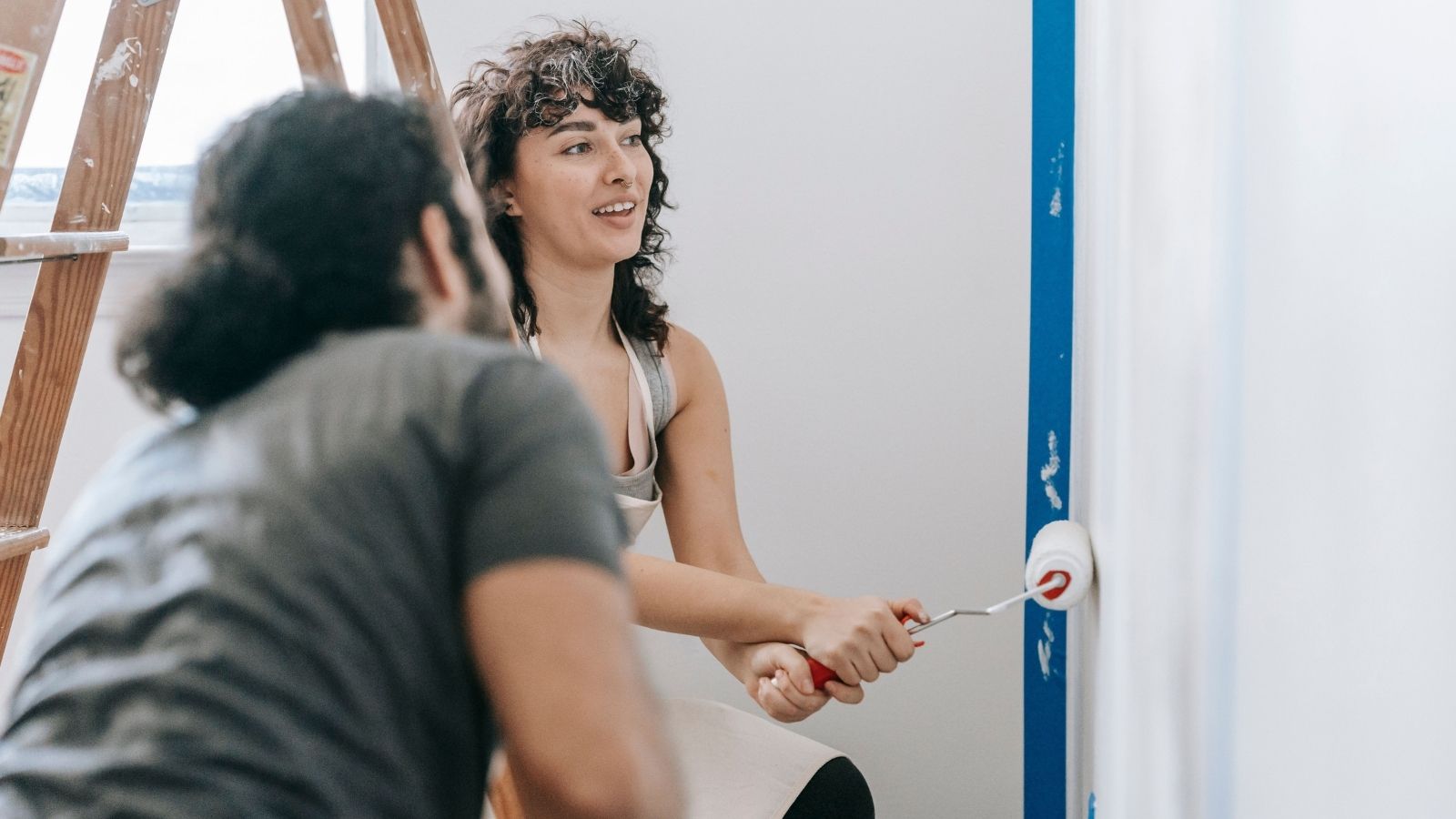 Couple painting their walls white to add value to their property