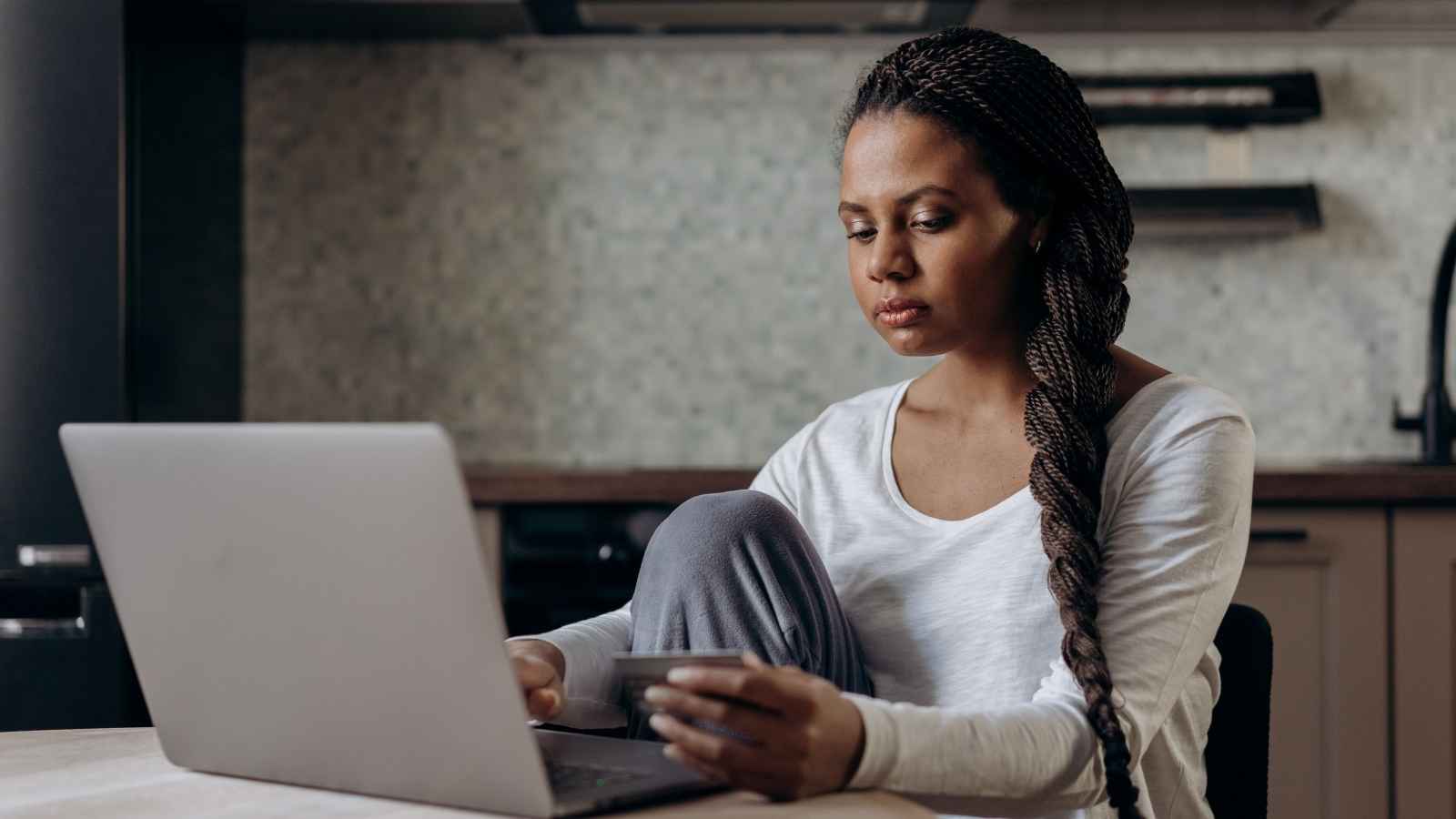 Person reviewing household expenses and a monthly budget at a kitchen table
