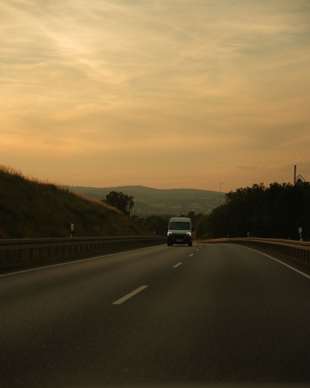 A van drives down a highway at dusk